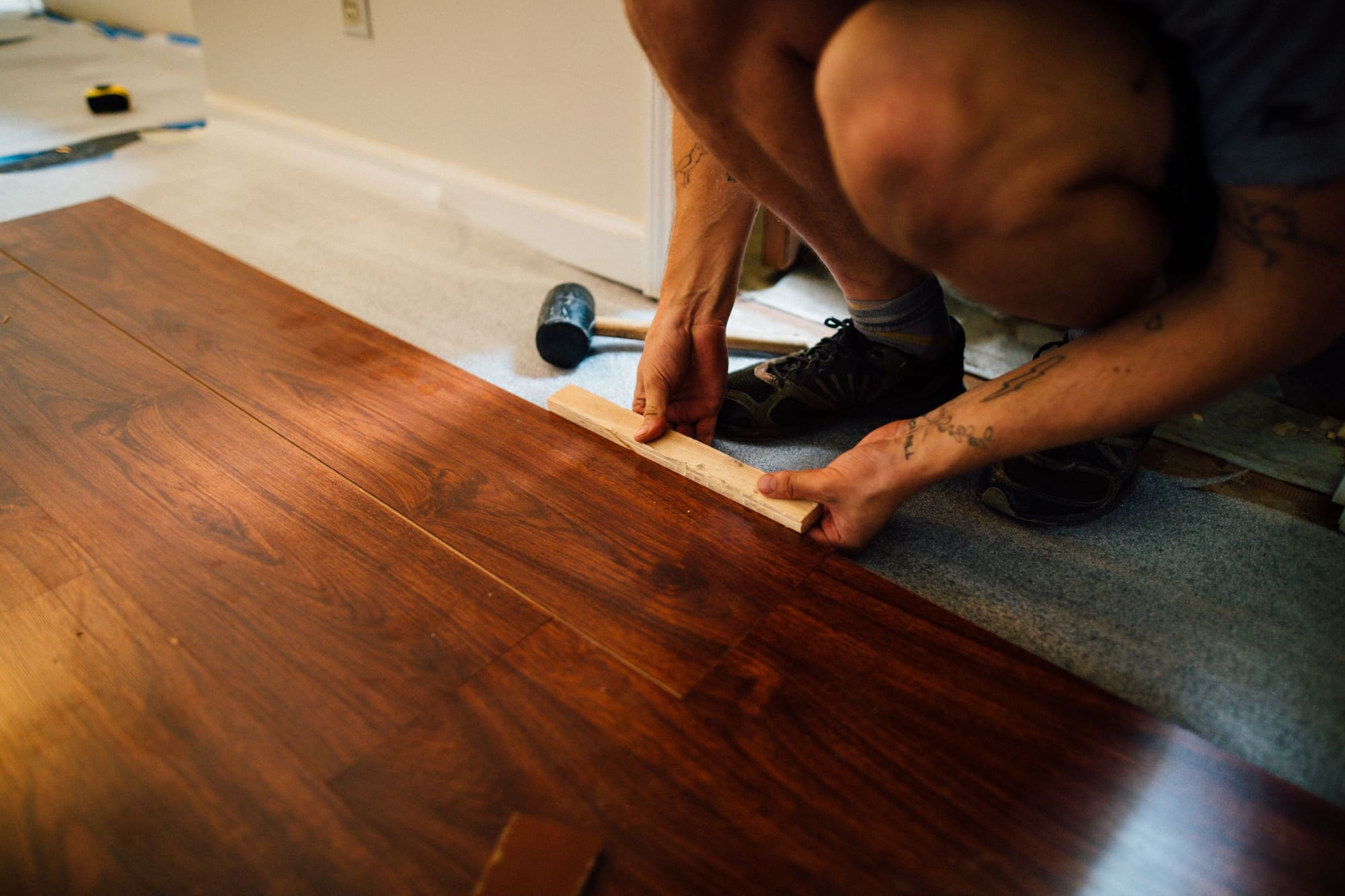 Person fitting wood-look flooring planks on an interior floor